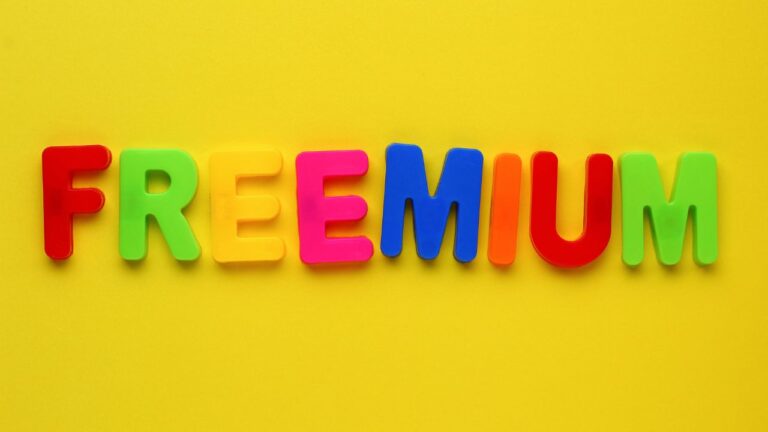 A palavra freemium escrita com letras coloridas de plástico sobre fundo amarelo, representando o conceito de gratuito com apelo visual infantil.