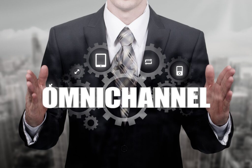 Homem de terno com ícones de canais digitais ao fundo representando o conceito de atendimento omnichannel.