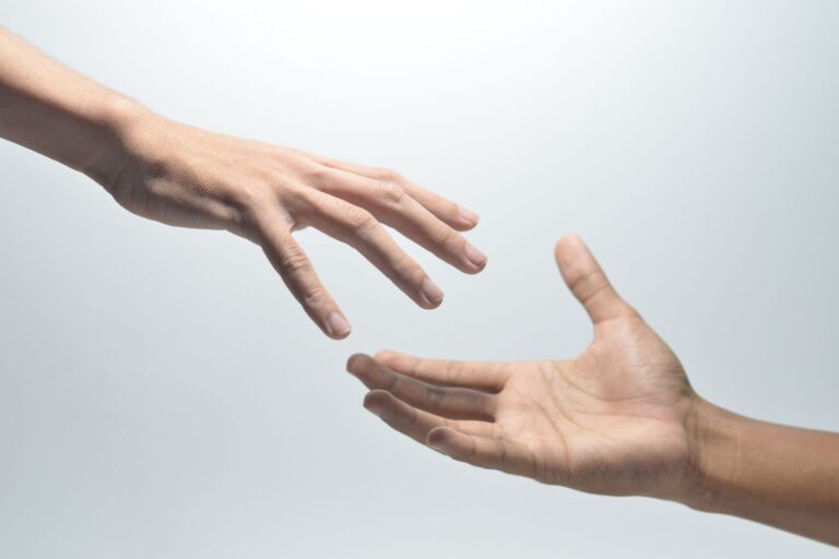 Duas mãos se estendendo uma para a outra, simbolizando conexão no alcance orgânico